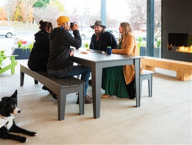 Group of friends with their dog, drinking by the fireplace at a restaurant patio