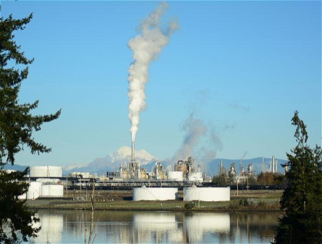 Photo of industrial facilities at a distance with Mount Ranier in the background