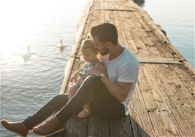Man and young girl sitting on a dock